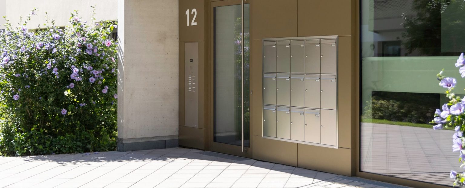 Hauseingang mit einer Unterputz-Briefkastenanlage in Edelstahl und Klingeltastern sowie Video Gegensprechanlage als einzelnes Element
