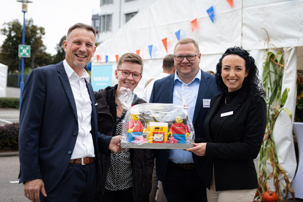 Geschäftsführer Thomas Kolbe (links) mit Ehefrau und Vertriebsleiterin Anna-Maria Kolbe (rechts) bei der Feierstunde – überreicht wurde ein Geschenk in Form eines LEGO-Briefkastens.