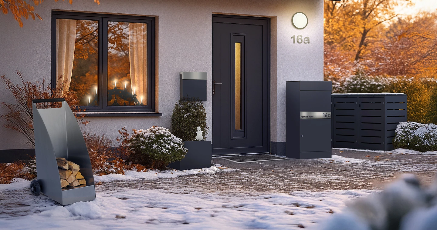 Hauseingang eines Einfamilienhauses mit Produkten von KNOBLOCH. Birefkasten, Mülltonnenbox, Paketbox, Gartenstecker und Kaminholzwagen