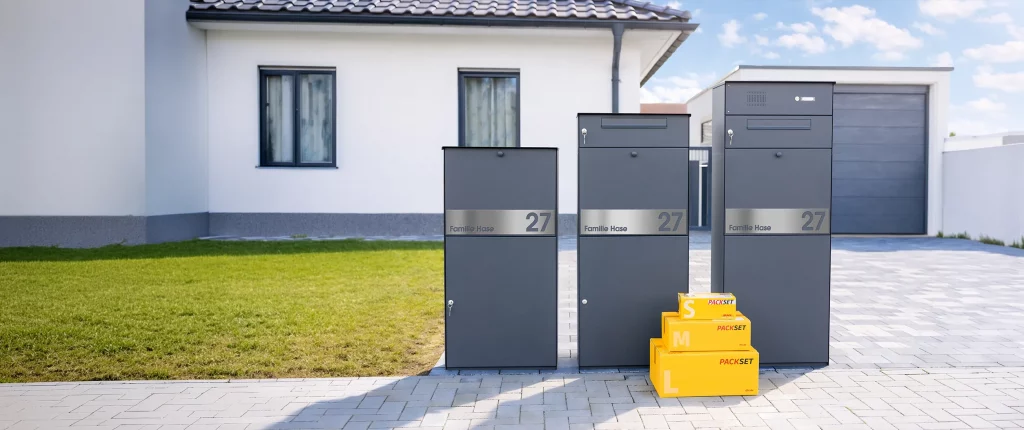 Paketbox KNOBOX PRO in Anthrazit in 3 Varianten vor einem Einfamilienhaus