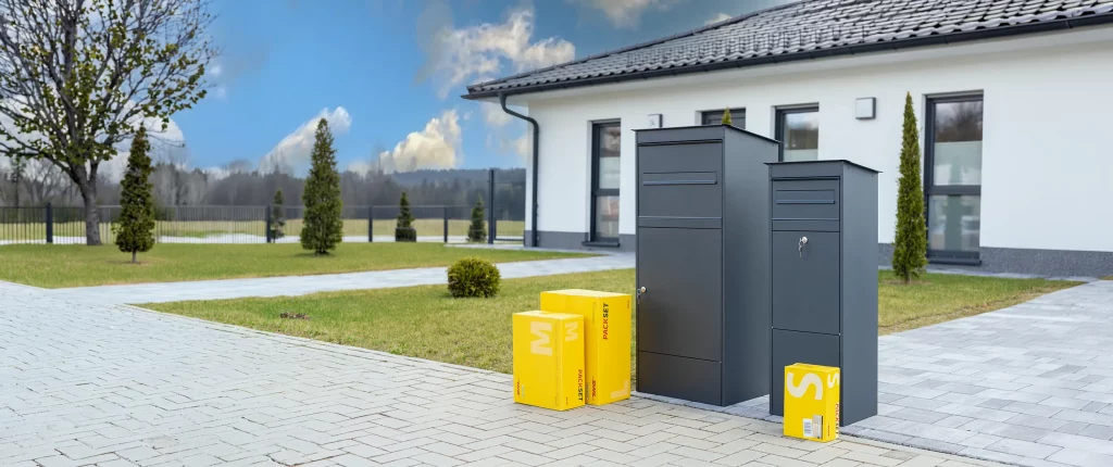 Paketbox JASPER und JASPER XL mit 3 gelben Paketen in unterschiedlichen Größen vor einem Einfamilienhaus