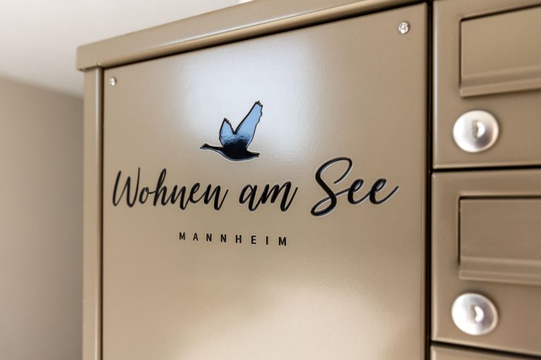 Briefkastenanlage mit schwarz ausgelegter Gravur des Logos